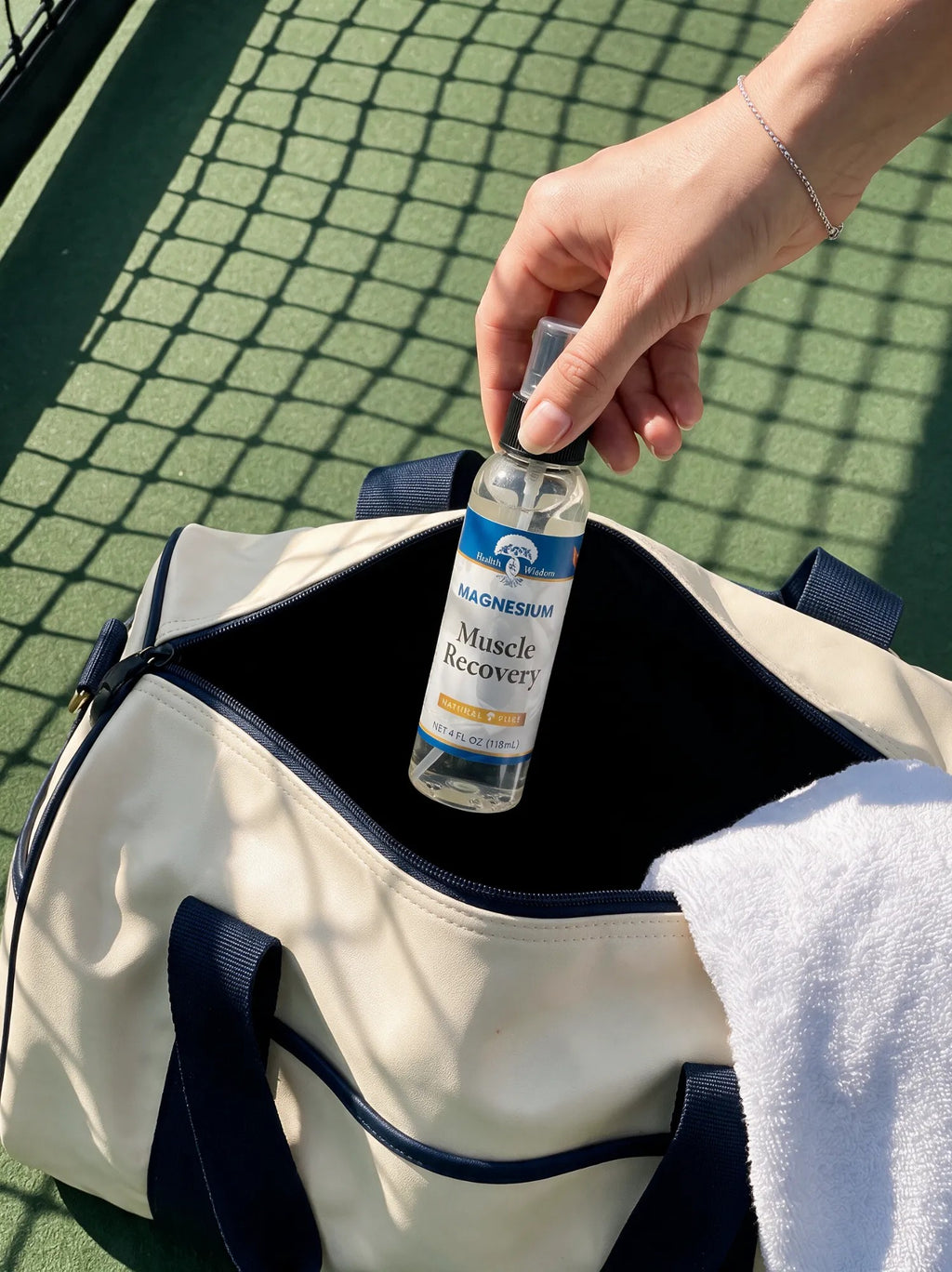 Hand taking the 4 oz magnesium spray out of a gym bag
