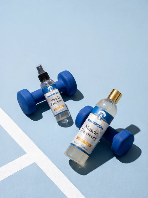 4 oz and 12 oz magnesium spray bottles resting on blue dumbbells